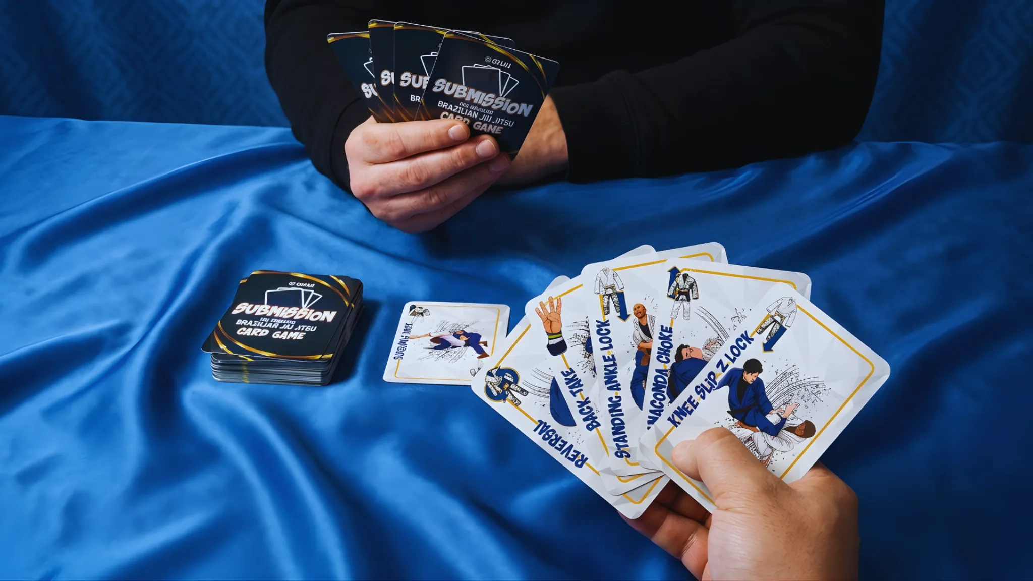 Hands holding a playable hand of Submission cards